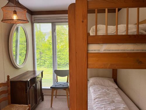 a bedroom with bunk beds and a desk and a window at Keizerskroon 239 in Julianadorp