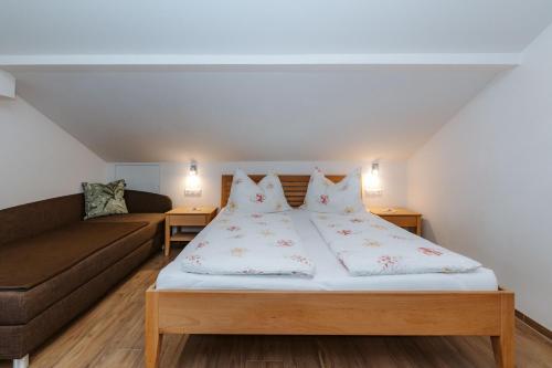 a bedroom with a bed and a couch at Appartement Lackner mit Seeblick in Weissensee