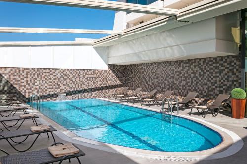 a pool in a hotel with chairs and a swimming pool at B Business Hotel & Spa in Antalya