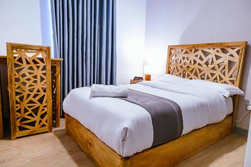 a bedroom with a bed with a wooden headboard at Apartment in Tilisi in Gatimu