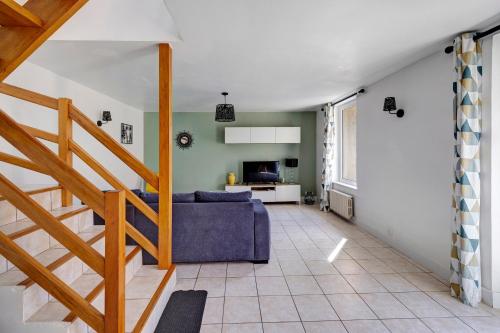 a living room with a blue couch and a staircase at Gite Aber 3km plages in Telgruc-sur-Mer