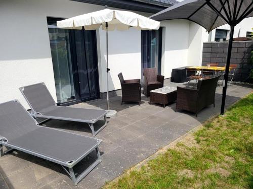 a patio with chairs and an umbrella and a table at Ferienwohnung Schmidt mit Terrasse in Neustrelitz