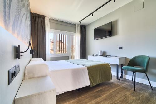 a hotel room with a bed and a chair at Hostal Sol y Miel in Benalmádena