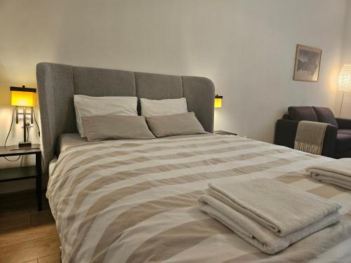a bedroom with a large bed with towels on it at Rynek Staromiejski Apartment in Koszalin