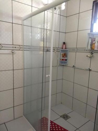 a shower with a glass door in a bathroom at Chalé casa na mata Jasmim in Guararema