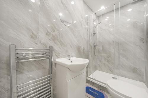 a bathroom with a sink and a shower and a toilet at The Cozy Stays Hackney House in London