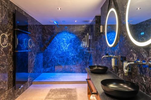 a bathroom with two sinks and a blue wall at Hotel MY Kramerwirt in Geiersthal