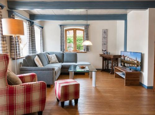 a living room with a couch and a table at Reetdachhaus Silvi in Schwabstedt
