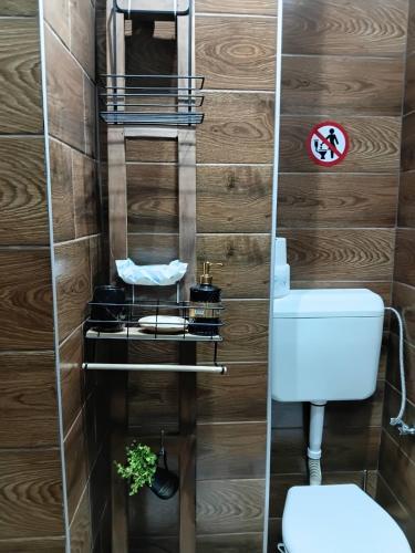 a bathroom with wooden walls and a toilet at Cozy in Sarajevo
