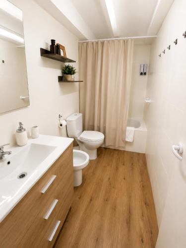 a white bathroom with a toilet and a sink at La Casonita in Alpuente