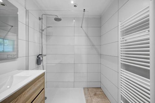 a white bathroom with a shower and a sink at Gite Dune 3km plage in Telgruc-sur-Mer
