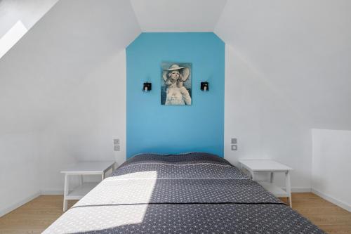 a bedroom with a bed with a blue wall at Gite Dune 3km plage in Telgruc-sur-Mer
