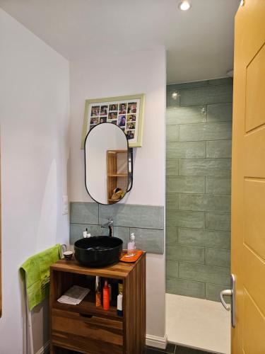 a bathroom with a sink and a mirror at Chambre privée proche GR & Véloroute in Plougonvelin