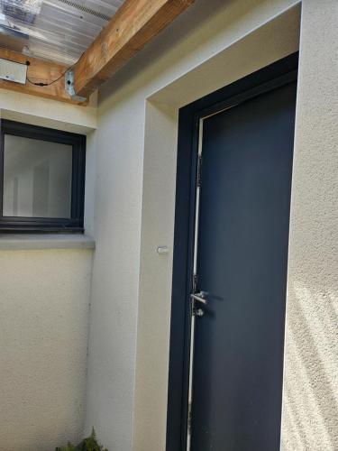 a blue door of a building with a window at Chambre privée proche GR & Véloroute in Plougonvelin