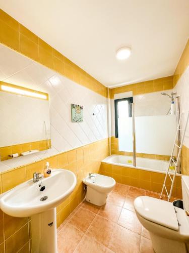 a bathroom with a sink and a toilet and a tub at Apartamento MN Estorde by ALÔGA in Vilar