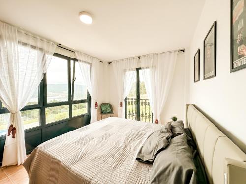 a bedroom with a large bed with a large window at Apartamento MN Estorde by ALÔGA in Vilar