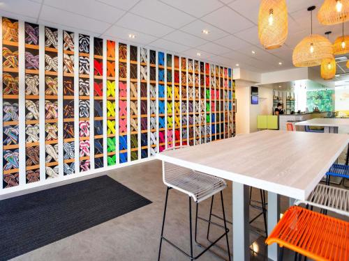 a room with a table and a wall of wine bottles at ibis Styles Perpignan Centre Gare in Perpignan