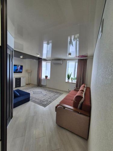 a large living room with a couch and a tv at Nest & Rest StuDio in Stavcheny
