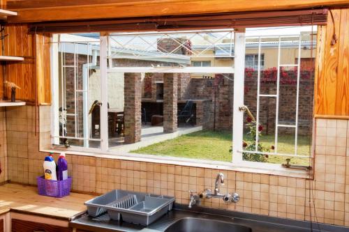 a kitchen with a sink and a window at Protea House in Graaff-Reinet