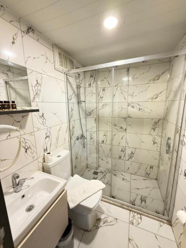 a bathroom with a toilet and a shower and a sink at Side Ertaş Otel in Side