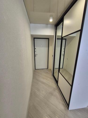 an empty hallway with a door and a mirror at Nest & Rest StuDio in Stavcheny