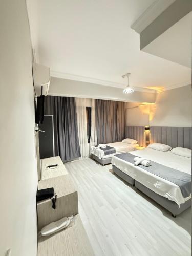 a hotel room with two beds and a mirror at Side Ertaş Otel in Side