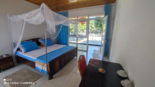 a bedroom with a bed and a table and a window at Forest Hotel in Miarinarivo