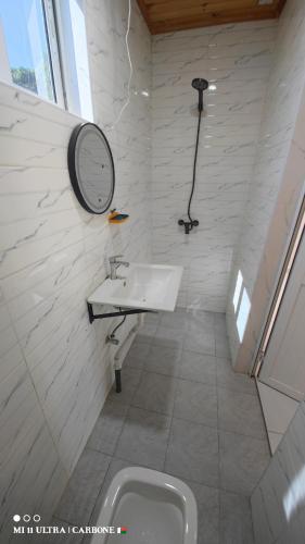 a white bathroom with a sink and a mirror at Forest Hotel in Miarinarivo