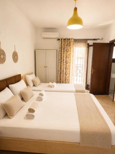 a bedroom with a large bed with two towels on it at Pension Anastasia in Ammouliani
