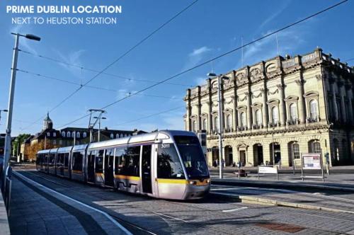 a train traveling down a street in front of a building at Destiny Student - Parkgate in Dublin
