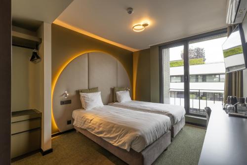 a bedroom with a large bed and a large window at Green Hotel in Genk