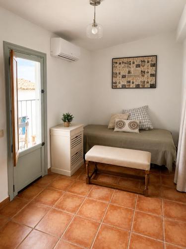 a bedroom with a bed and a table and a window at La Casonita in Alpuente