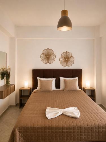 a bedroom with a bed with a bow on it at Alkyonari By Maria in Ammouliani