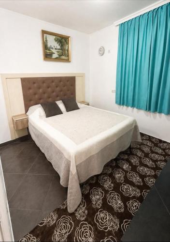 a bedroom with a large bed with blue curtains at Apartmani Blu Notte in Ulcinj