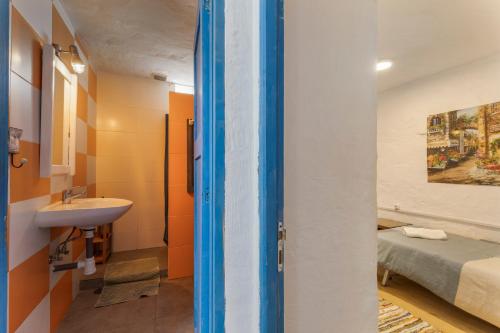 a bathroom with a sink and a toilet and a bed at Oaxaca Iguana in Agaete