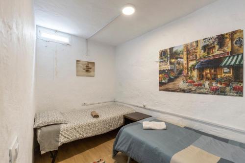 a room with two beds and a painting on the wall at Oaxaca Iguana in Agaete