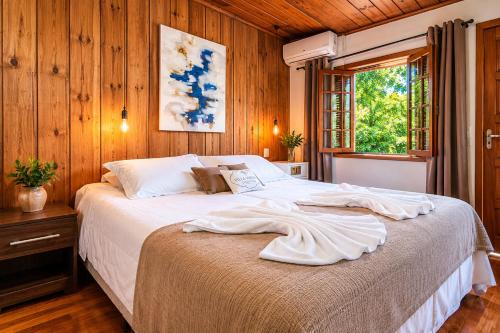 En eller flere senge i et værelse på Villa Vintage Campos - Piscina e opções de suites com hidromassagem