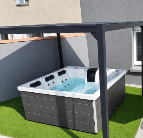 a hot tub on a patio with green grass at Villa Bella & Spa in Mouilleron-le-Captif