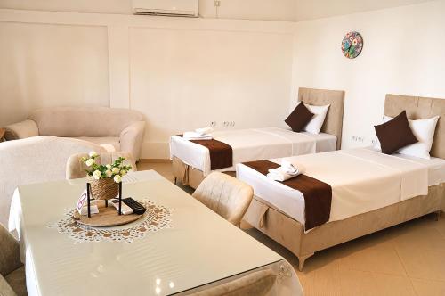 a hotel room with two beds and a table at Kalinovi Apartments in Gevgelija