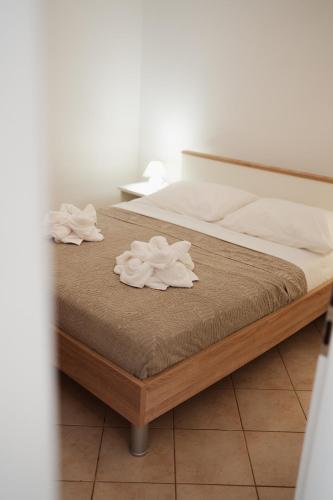 a bed with two white towels on top of it at OLIVE in Nerezine