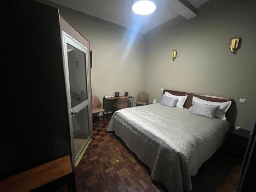 a bedroom with a white bed and a mirror at Le felix in Antananarivo