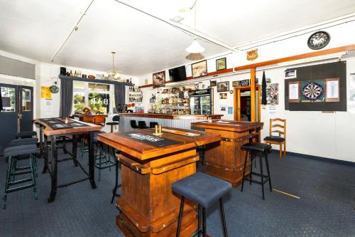 a bar with wooden tables and chairs in a restaurant at Ahaura Hotel in Greymouth