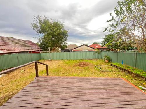 a wooden boardwalk leading to a yard with a fence at Room 73 in Merrylands