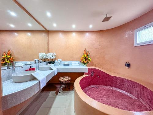 a bathroom with three sinks and a bath tub at Le Lodge des Almadies in Dakar