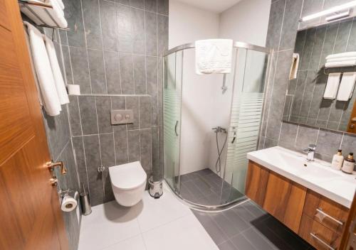 a bathroom with a shower and a toilet and a sink at Istanbul Airport Express Hotel in Arnavutköy