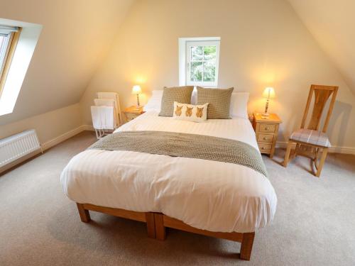 a bedroom with a large white bed in a attic at Bobblehat Barn in Alford