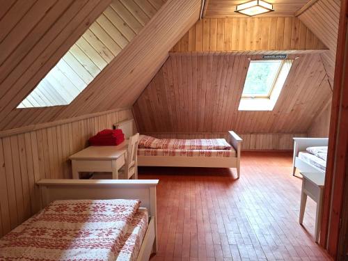 a attic room with two beds and a window at Sika Holiday Houses in Hellamaa