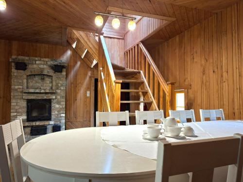 a dining room with a table and chairs and a fireplace at Sika Holiday Houses in Hellamaa