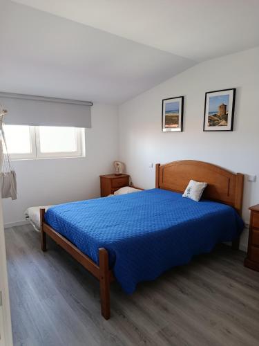 a bedroom with a bed with a blue comforter at Casa de Férias Terra e Mar in Póvoa de Varzim