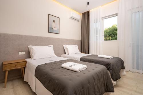a hotel room with two beds and a window at Villa V - Infinity Holiday Villas, For Large Groups With Private Pool, by ZanteWize in Kalamaki